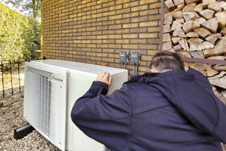 Man installeert Daikin warmtepomp aan de zijgevel